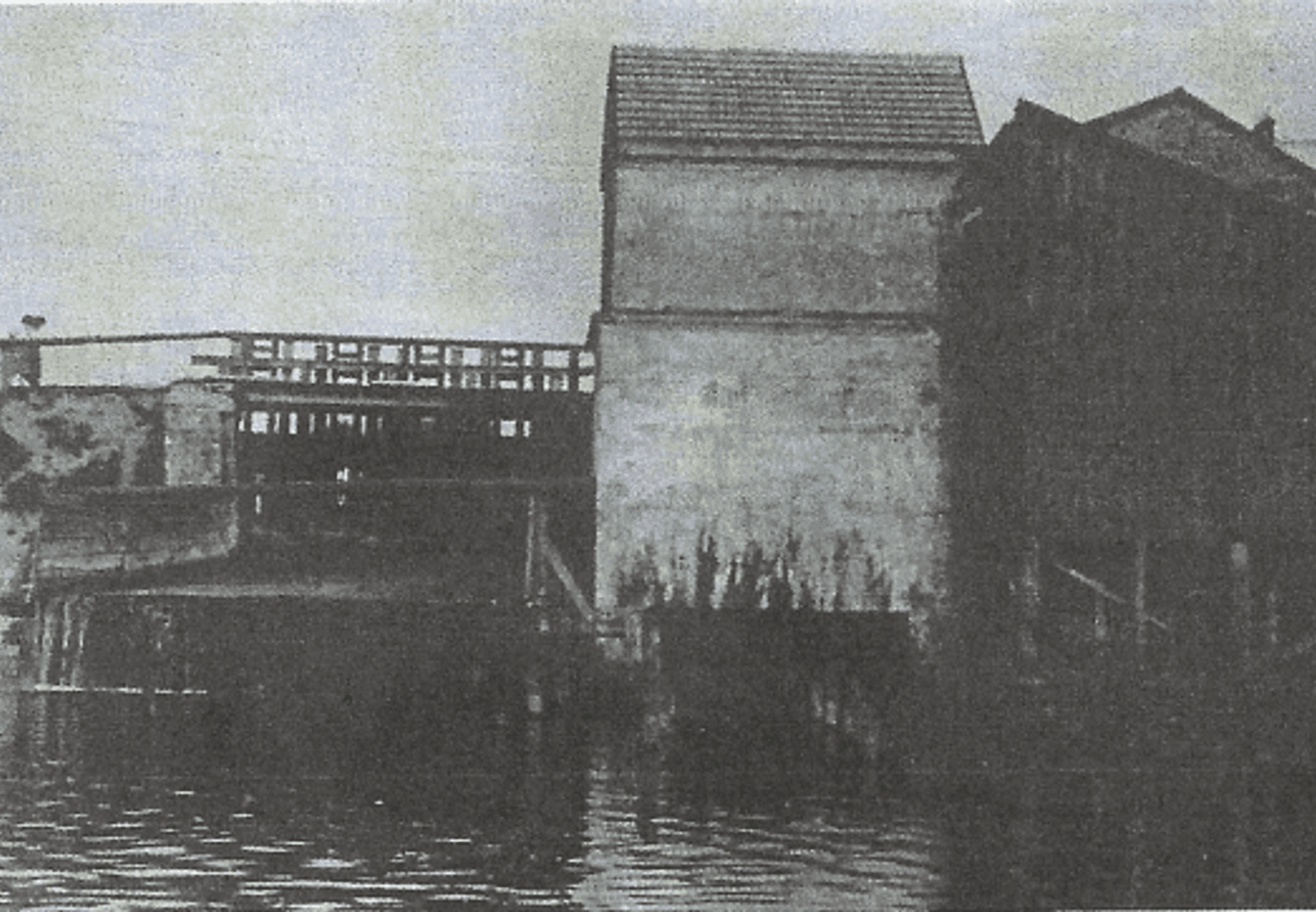 Historyczny widok na rzekę i zabudowania przy młynie